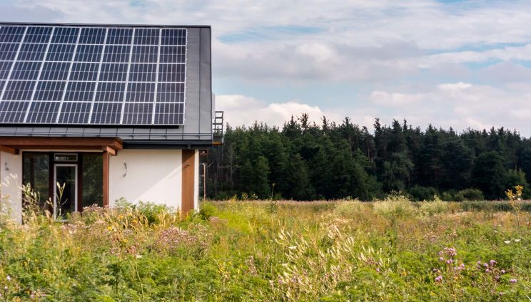 Off Grid Solar House with solar panels in off-grid grassland